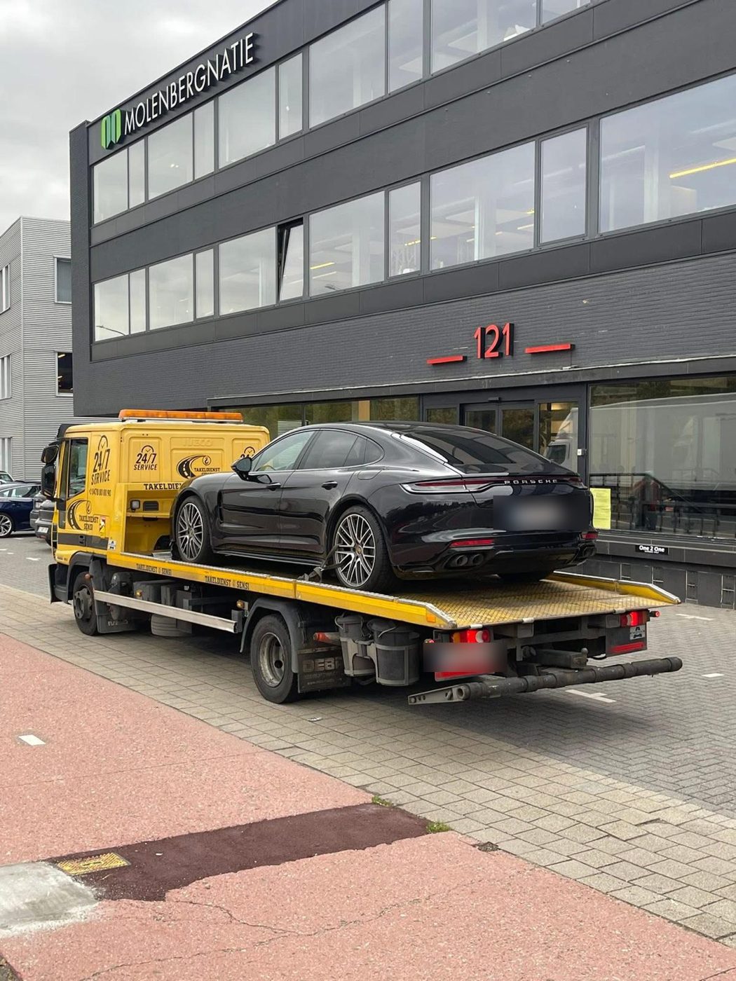 Zwarte Porsche Panamera op de oplegger van Takeldienst Sensi in Antwerpen
