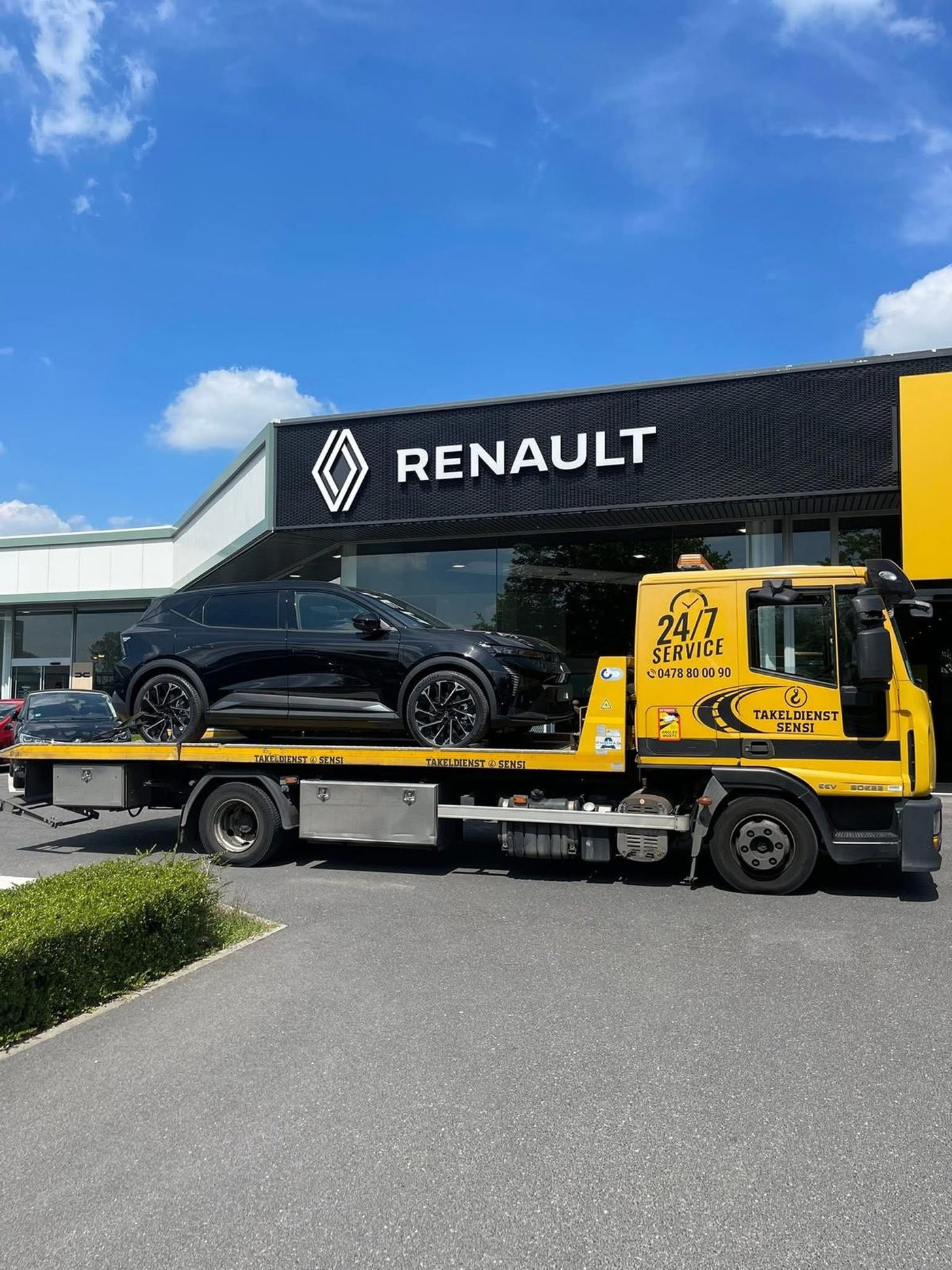 Zwarte Renault Rafale op de takelwagen voor een Renault-garage