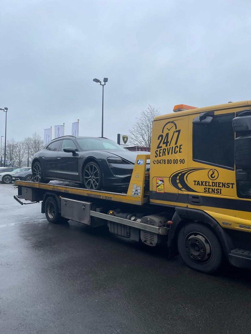 Porsche Taycan op de takelwagen van Takeldienst Sensi bij een autodealer