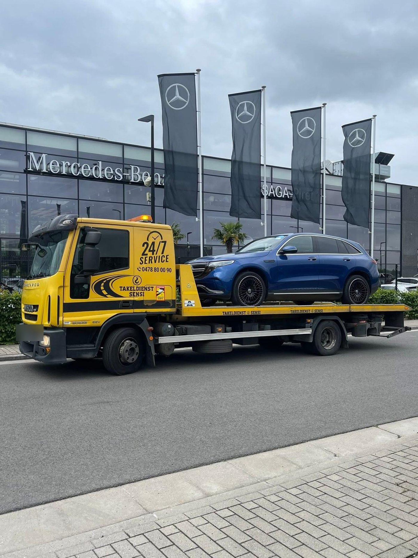 Blauwe Mercedes EQC op de takelwagen voor een Mercedes-Benz garage